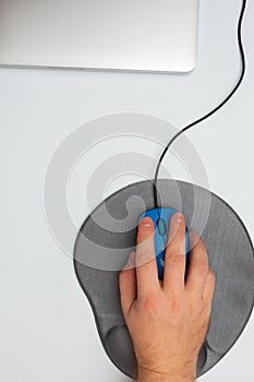 Male hand with mouse, pad and notebook computer on white