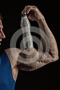 Male hand of muscular man with biceps, triceps, drink bottle