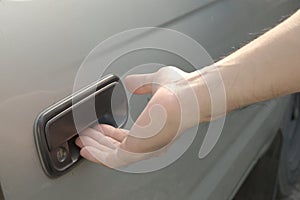 Male hand opening car door from outside