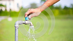 Male hand opens the garden water tap, pouring clean fresh water water tap, turn on tap,Hands-off water.