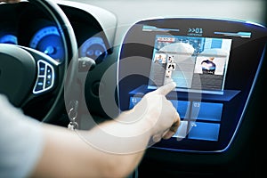 Male hand pointing finger to monitor on car panel