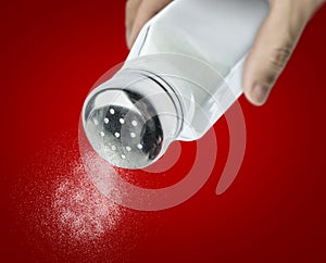 Male hand pouring salt from a salt shaker photo