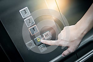 Male hand pressing on emergency button in elevator