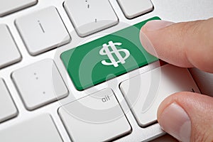 Male hand pressing green button dollar icon computer key