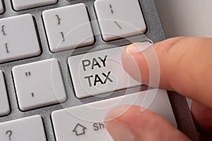 Male hand pressing keyboard button PAY TAX. Business online concept