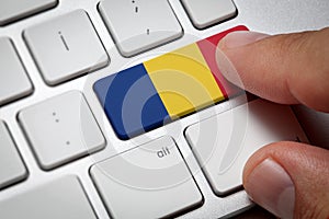 Male hand pressing keyboard key.Romania flag button