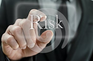 Male hand pressing Risk icon on a virtual screen