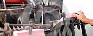 Male hand pressing the stack of paper for printing with the letterpress printing old machinery. The machine for bill or notebook
