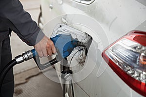 Male hand pumping petrol into car at gas station photo