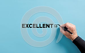 Male hand puts checkmark next to the word excellent. Customer performance evaluation