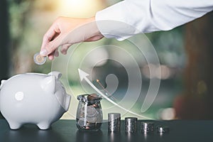 Male hand putting coin money into piggy bank,finance and banking, fund growth and savings concept, proportional money management
