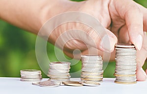 Male hand putting money coin like stack growing business