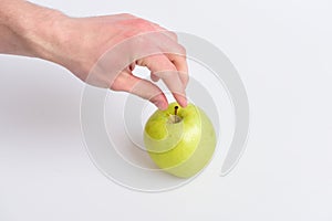 Male hand reaches light green apple. Apple fruit on white