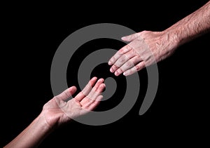 Male hand reaching to touch woman hand.