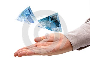 Male hand receiving prize, 100 reais banknote falling on his hand, grand prize or payout