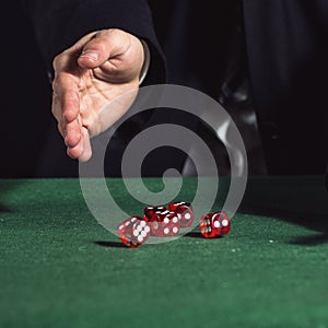 Male hand rolling five dice