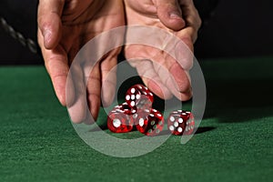 Male hand rolling five dice
