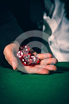 Male hand rolling five dice