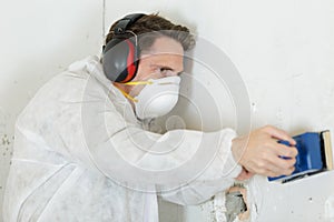 male hand sanding patch in drywall photo