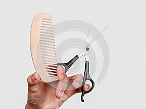 Male hand with scissors and comb