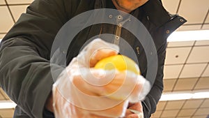 Male hand selecting lemons at the supermarket. Young man taking some lemons from counter in a grocery store. Guy