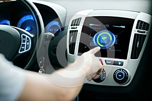 Male hand setting car eco system mode on screen