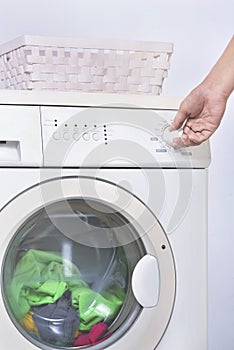 Male hand setting the program on washing machine