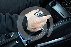 male hand shifts gears on the automatic transmission lever