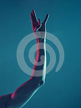 Male hand in shocker gesture on neon blue light background. Concept photography, poster