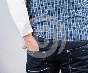 male hand shoved into the back jeans pocket