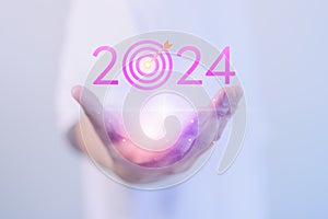 Male hand show the goal 2024 icon, target for working, success, savings money, good health, life balance, travel plan