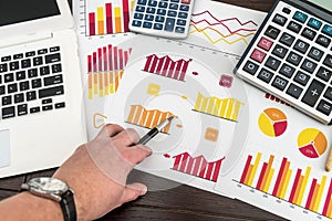 Male hand showing diagram or chart on financial report with pen