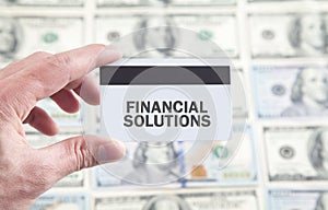 Male hand showing Financial Solutions text on credit card