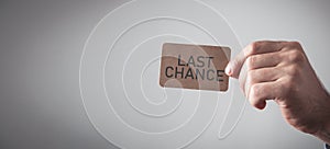 Male hand showing Last Chance message on cardboard card