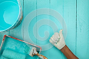 Male hand showing thumbs up with painting blue color on wooden t