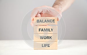 Male hand showing wooden block. Life. Work. Family. Balance