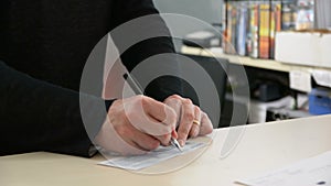 Male hand signing check and receiving contract