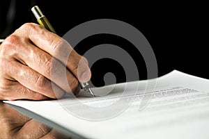 Male hand signing a contract, employment papers, legal document photo