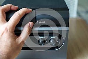 Male hand on a speaker volume knobs
