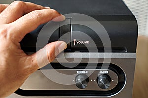 Male hand on a speaker volume knobs