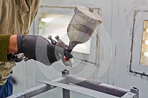 Male hand with spray paint gun, painting car details