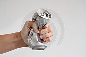 male hand squeezes an empty aluminum can for recycling. expression of anger and powerlessness.