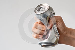 Male hand squeezes an empty aluminum can for recycling