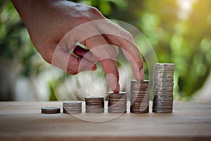 Male hand stack coins same stair like growing for the future, education, home, loan and child on sunlight background