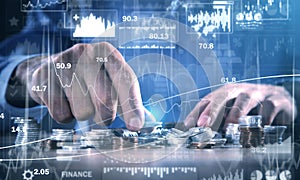 Male hand stacking coins. Investment graphs and charts