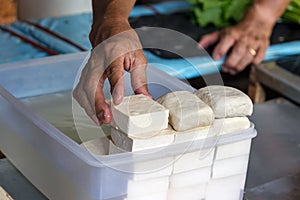 Male hand stacking tofu vegan cheese at the Port Louis in Mauritius