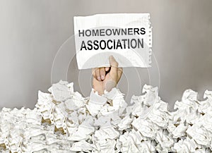 Male hand take a paper with text Homeowners Association with a lot of another paper