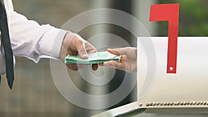 Male hand taking euro banknotes from mail box, remittance service money transfer