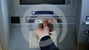 Male hand taking euros from ATM top view, withdrawing cash, business trip photo