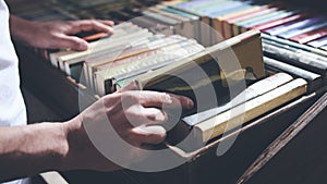 Male hand taking out a book from a bookshelf